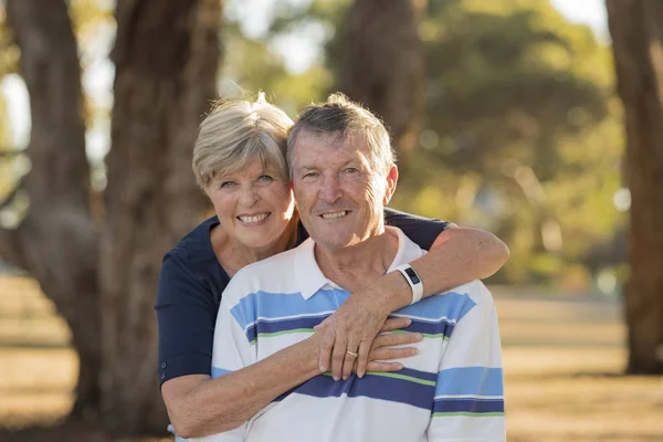 Портрет американський старший красивою і щасливою Літня пара близько 70 років показують любові і ласки, посміхаючись разом в парку — стокове фото
