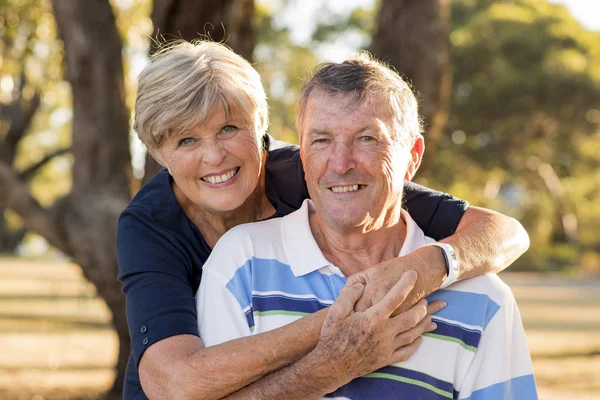 Retrato de americano senior hermosa y feliz pareja madura alrededor de 70 años de edad mostrando el amor y el afecto sonriendo juntos en el parque —  Fotos de Stock