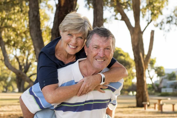 Портрет американський старший красивою і щасливою Літня пара близько 70 років показують любові і ласки, посміхаючись разом в парку — стокове фото