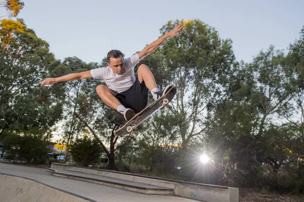 Pria berlatih papan seluncur radikal melompat dan menikmati trik dan stunts dalam beton setengah jalur skating pipa dalam olahraga dan gaya hidup sehat — Stok Foto