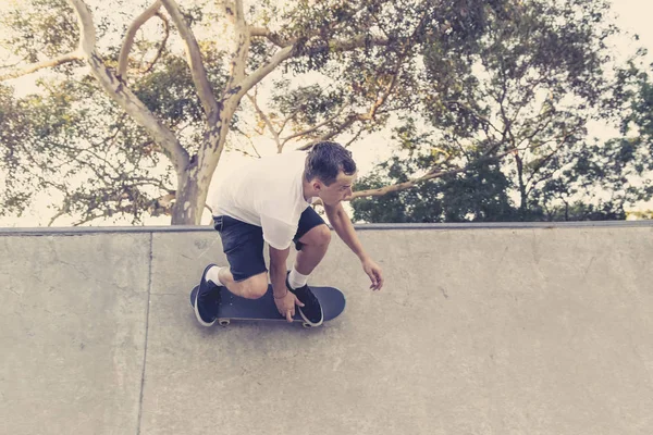 Pria berlatih papan seluncur radikal melompat dan menikmati trik dan stunts dalam beton setengah jalur skating pipa dalam olahraga dan gaya hidup sehat — Stok Foto