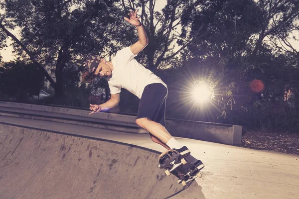Hombre practicando skate board radical saltando y disfrutando de trucos y acrobacias en pista de patinaje de medio tubo de hormigón en el deporte y estilo de vida saludable — Foto de Stock
