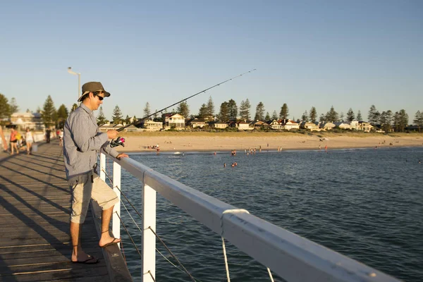 Muda menarik dan bahagia pria di kemeja dan topi memancing di pantai — Stok Foto