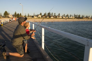 Baba birlikte denizde Balık tutma bir balıkçı olmak küçük oğlunun öğretim zevk ve balık çubuk kullanarak öğrenme dolgu rıhtım