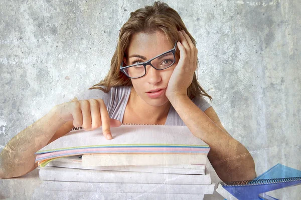 Atractiva y hermosa chica estudiante cansado apoyándose en los libros de la escuela pila cansado y aburrido después de estudiar preparación examen buscando desperdiciado —  Fotos de Stock