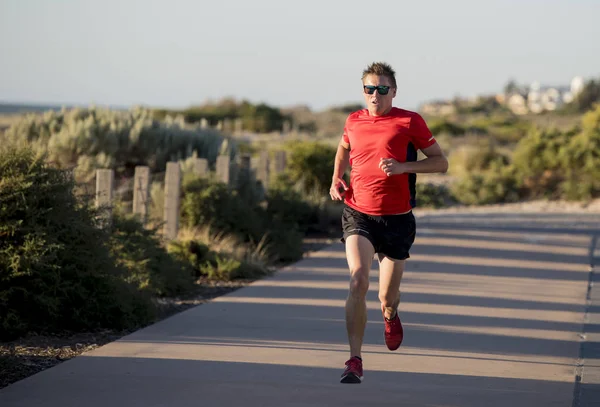 Joven corredor deportivo atractivo y feliz hombre con ajuste y un fuerte entrenamiento corporal saludable en la pista fuera de la carretera en el verano corriendo entrenamiento —  Fotos de Stock