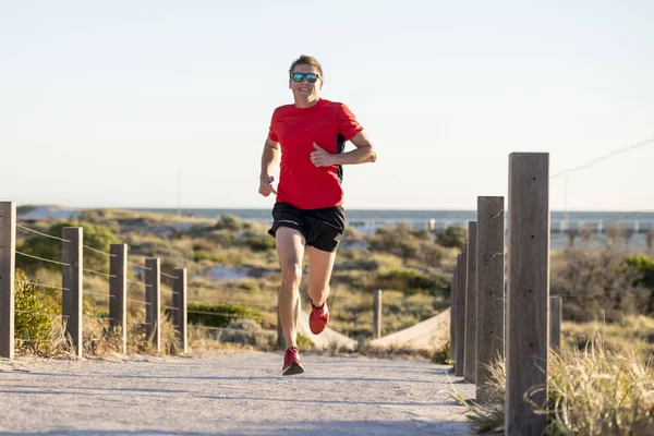 Jonge aantrekkelijke en gelukkig sport runner man met pasvorm en sterke gezonde lichaamstraining op weg op de weg in de zomer met training — Stockfoto