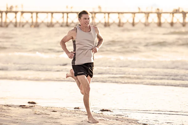 Forme athlétique et forte entraînement homme coureur sur la plage de coucher de soleil d'été dans la course au rivage de la mer et entraînement de fitness dans le sport et mode de vie sain concept — Photo
