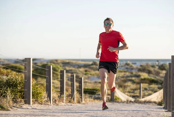 Jovem atraente e feliz homem corredor do esporte com ajuste e forte treinamento corporal saudável na pista off-road no verão exercício de corrida — Fotografia de Stock