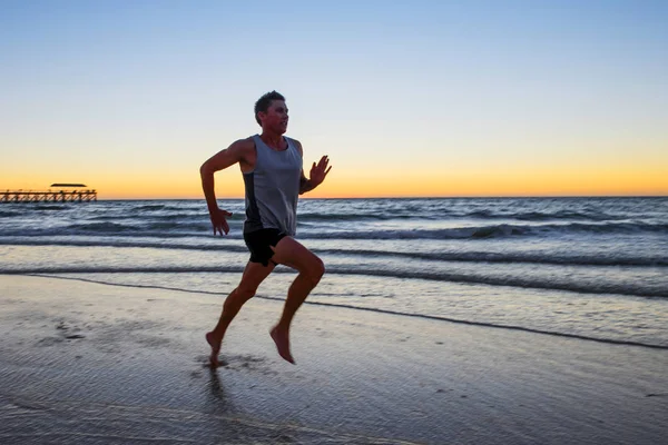 Atlet fit dan kuat pelari pelatihan manusia di musim panas matahari terbenam pantai di pantai menjalankan laut dan latihan kebugaran dalam olahraga dan gaya hidup sehat — Stok Foto
