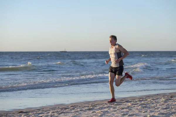 Atlet fit dan kuat pelari pelatihan manusia di musim panas matahari terbenam pantai di pantai menjalankan laut dan latihan kebugaran dalam olahraga dan gaya hidup sehat — Stok Foto