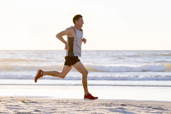 Atlético ajuste e forte corredor homem formação no verão pôr do sol praia no mar costa corrida e fitness treino no esporte e estilo de vida saudável — Fotografia de Stock