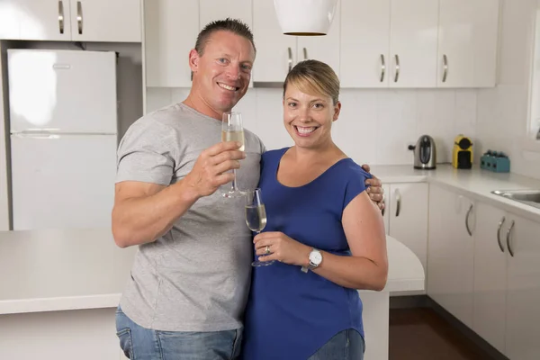 Joven hermosa pareja 30s o 40s en amor celebrando juntos aniversario o día de San Valentín con champán o vino tostadas en casa sonriendo feliz —  Fotos de Stock