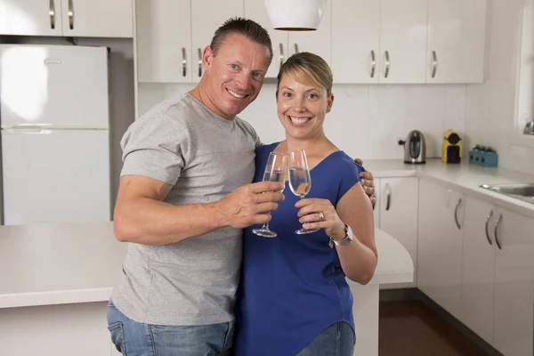 Joven hermosa pareja 30s o 40s en amor celebrando juntos aniversario o día de San Valentín con champán o vino tostadas en casa sonriendo feliz —  Fotos de Stock