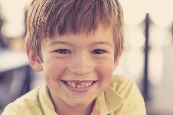 Close up headshot portrait of young little 7 or 8 years old boy with sweet funny teeth smiling happy and cheerful in joy face expression — Stock Photo, Image