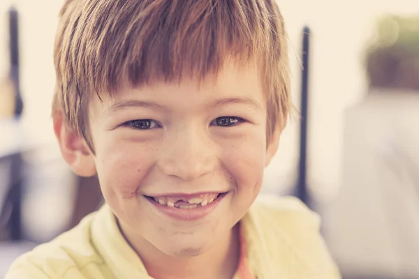 Close up headshot portrait of young little 7 or 8 years old boy with sweet funny teeth smiling happy and cheerful in joy face expression — Stock Photo, Image