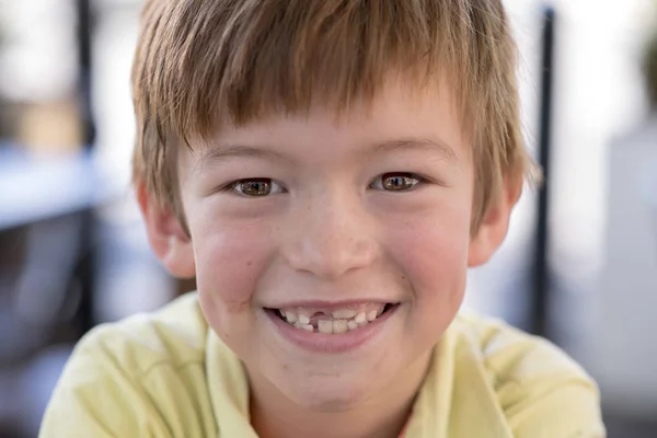 Close up headshot portrait of young little 7 or 8 years old boy with sweet funny teeth smiling happy and cheerful in joy face expression — Stock Photo, Image