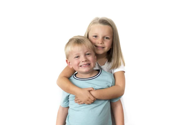 7 anos de idade adorável loira feliz menina posando com seu pequeno 3 anos de idade irmão sorrindo alegre isolado no fundo branco — Fotografia de Stock