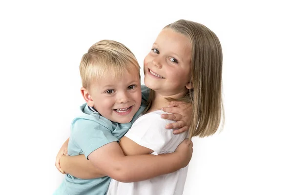 7 jaar oude schattige blonde gelukkig meisje poseren met haar kleine 3 jaar oude broer lacht vrolijk geïsoleerd op witte achtergrond — Stockfoto