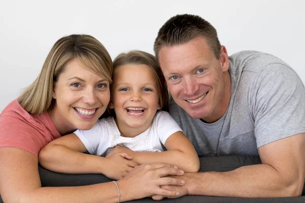 Young beautiful and happy Caucasian couple with mother and father posing cheerful together with adorable 7 years old blond little girl — Stock Photo, Image