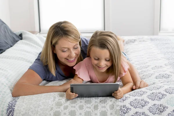 Blond Caucasian mother lying on bed with her young sweet 7 year — Stock Photo, Image