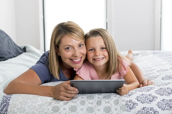 Blond Kaukasische moeder liggend op bed met haar jonge zoete 7 jaar — Stockfoto
