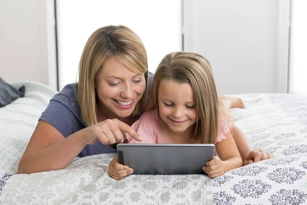 Blond Caucasian mother lying on bed with her young sweet 7 year — Stock Photo, Image