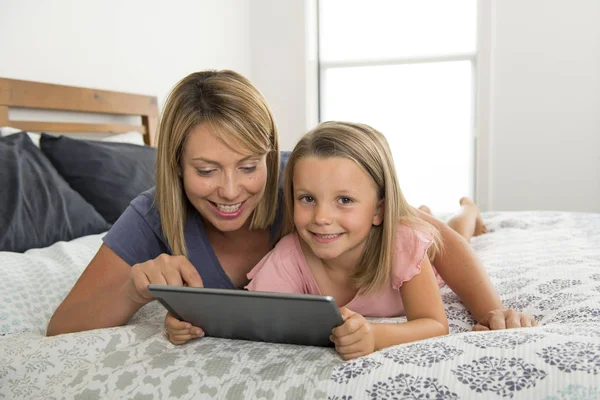 Blond Caucasian mother lying on bed with her young sweet 7 year — Stock Photo, Image