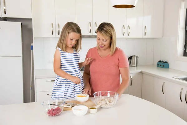 年轻的母亲和甜美的小女儿一起烘烤在家庭生活中快乐家居厨房的概念 — 图库照片