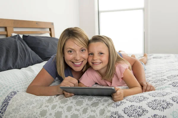 Blond Caucasian mother lying on bed with her young sweet 7 year — Stock Photo, Image