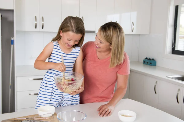 金发女郎烹饪和烘烤快乐一起与可爱可爱迷你厨师小女孩在家里厨房里的母亲和女儿的爱 — 图库照片
