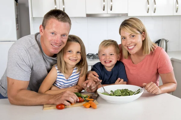 年轻有吸引力的夫妇母亲和父亲准备沙拉一起与小儿子和年轻美丽的女儿在健康蔬菜营养 — 图库照片