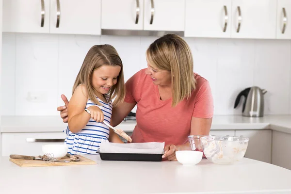 Jovem mãe e doce filhinha assar juntos feliz em casa cozinha no conceito de estilo de vida familiar — Fotografia de Stock