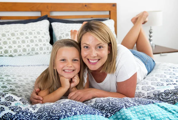 Junge blonde Kaukasierin liegt zusammen mit ihrem Jungen auf dem Bett — Stockfoto