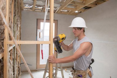 Genç Oluşturucu sanayi stajyer adam matkapla endüstriyel atölye sitesinde çalışma koruyucu kask öğrenme giyen onun 20s