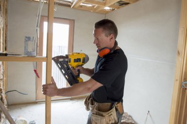 Endüstriyel inşaat sahasında elektrikli matkap ile çekici ve kendinden emin Oluşturucu marangoz veya Oluşturucu adam çalışma ağaç