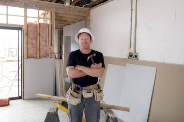 koruyucu kask poz, çekici ve kendinden emin Oluşturucu marangoz veya Oluşturucu adam endüstriyel inşaat alanında çalışan mutlu 