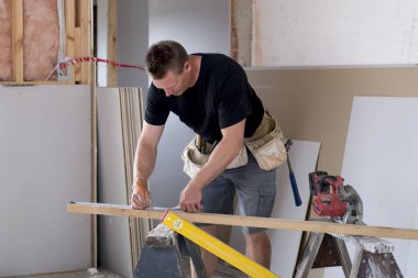 çalışma ve endüstriyel inşaat alanında ölçüm koruyucu kask içinde mutlu çekici ve kendinden emin Oluşturucu marangoz veya Oluşturucu adam