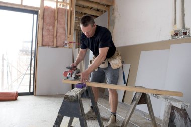 Endüstriyel inşaat iş kavramı kesme ahşap elektrik ile çalışan çekici ve kendinden emin Oluşturucu marangoz veya Oluşturucu adam gördüm