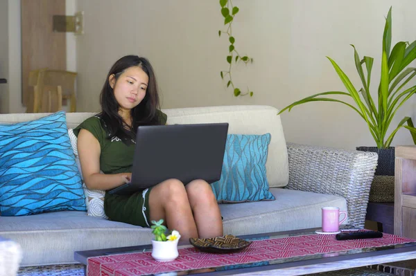 젊은 아름 답 고 편안한 아시아 중국에 여자 그녀의 20 대 또는 30 대 행복 작업 또는 컴퓨터 노트북을 사용 하 여 거실 가정 소파 소파에 앉아 — 스톡 사진