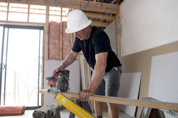 çekici ve kendinden emin Oluşturucu marangoz veya Oluşturucu adam koruyucu kask mutlu kesim ahşap sanayi inşaat alanında çalışma içinde