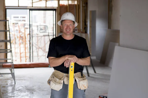 Charpentier constructeur attrayant et confiant ou constructeur homme avec chapeau de protection posant heureux de travailler dans la construction industrielle concept d'emploi — Photo