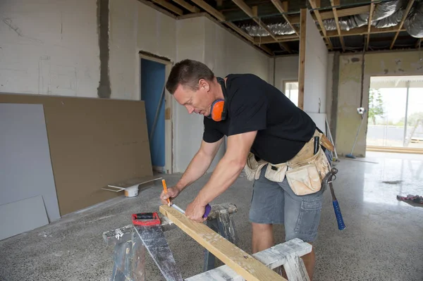 Endüstriyel inşaat alanında manuel ölçüm ahşap çalışma çekici ve kendinden emin Oluşturucu marangoz veya Oluşturucu adam gördüm 