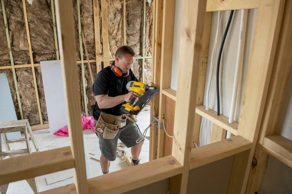 Attrayant et confiant constructeur charpentier ou constructeur homme de travail du bois avec perceuse électrique sur le chantier de construction industrielle — Photo