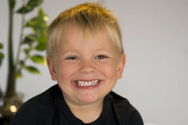 Portrait of blond beautiful 3 or 4 years old caucasian kid smiling happy in joyful face expression isolated at home looking to camera — Stock Photo, Image