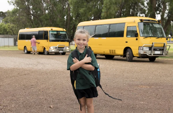 Όμορφη ξανθιά καυκάσιος γυναίκα παιδί αναμονή για σχολικό λεωφορείο που μετέφερε σακίδιο χαμογελά ευτυχισμένη στο νεαρό κορίτσι μαθητής και μαθήτρια έτοιμη έννοια — Φωτογραφία Αρχείου