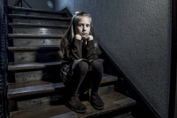 Niña de 7 u 8 años triste deprimida y preocupada sentada en la escalera desesperada y asustada sufriendo acoso escolar — Foto de Stock