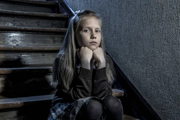 7 ou 8 anos triste deprimida e preocupada estudante sentada em escada desesperada e assustada sofrendo bullying e assédio na escola — Fotografia de Stock