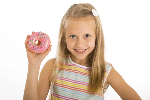 Cantik muda bahagia dan gembira gadis pirang 8 atau 9 tahun memegang gurun donat di tangannya tampak kejang dan ceria dalam pelecehan gula dan kecanduan — Stok Foto