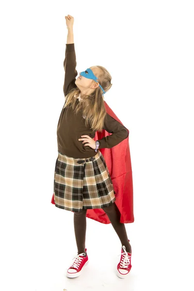 7 o 8 anni giovane bambina in costume da supereroe sopra uniforme scolastica esibendosi felice ed eccitato isolato su sfondo bianco — Foto Stock